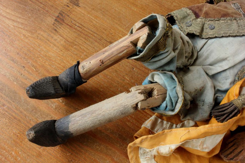An antique French folk art marionette puppet with a hand-carved bearded wooden head, articulated limbs, and a brown velvet jacket trimmed with braid. View VIII