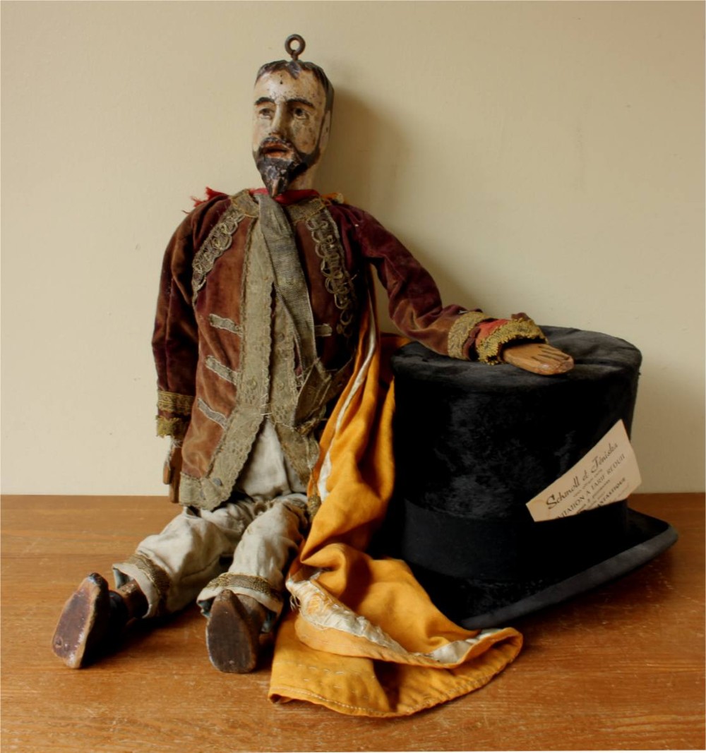 An antique French folk art marionette puppet with a hand-carved bearded wooden head, articulated limbs, and a brown velvet jacket trimmed with braid. View IX