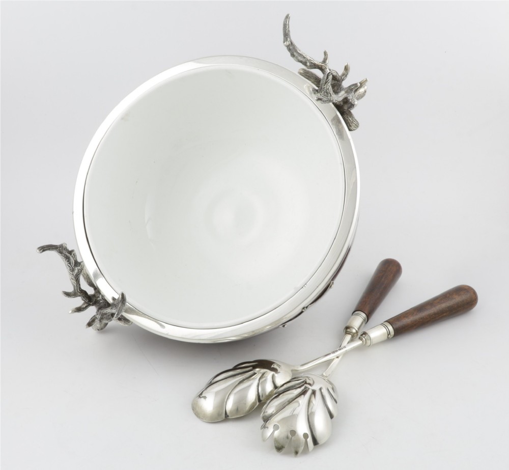 A turned dark oak bowl featuring a silver-plated rim, cast stag head handles, a central vacant silver shield, and matching serving utensils. View II