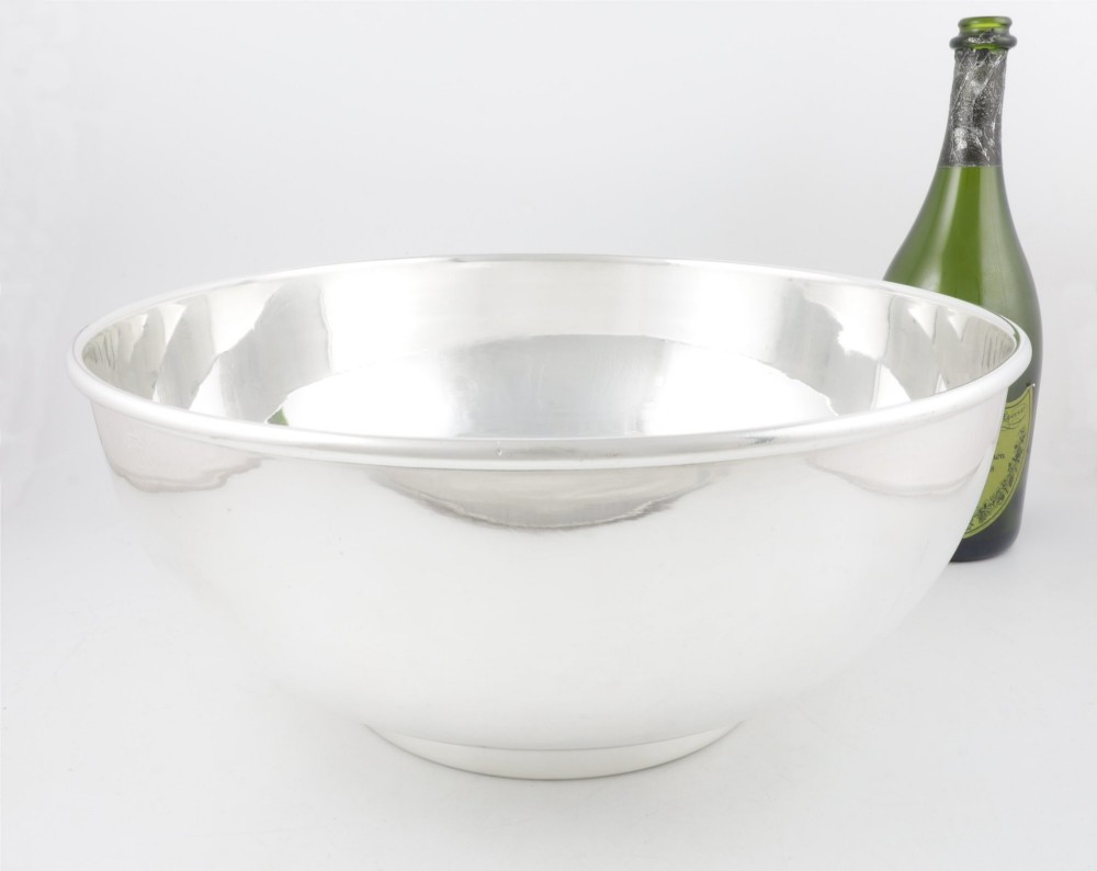 A large polished silver-plated champagne cooler bowl featuring a smooth circular basin, rolled rim, and pedestal base.