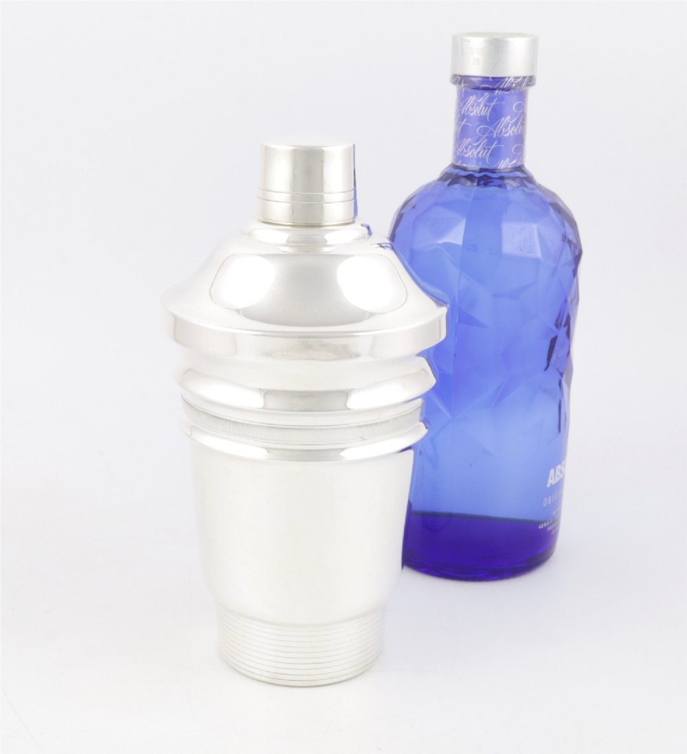 A 1930s Art Deco silver-plated cocktail shaker featuring stepped geometric contours and fine engine-turned band details. View V