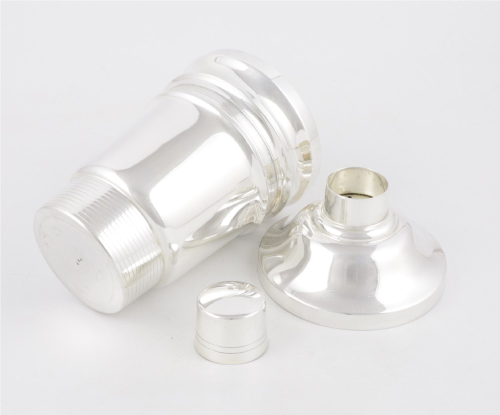 A 1930s Art Deco silver-plated cocktail shaker featuring stepped geometric contours and fine engine-turned band details. View VII