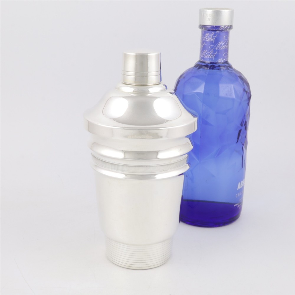 A 1930s Art Deco silver-plated cocktail shaker featuring stepped geometric contours and fine engine-turned band details. View XII