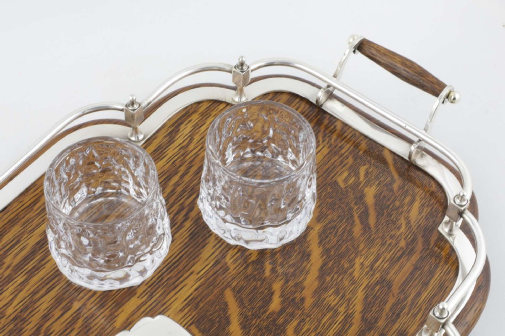A late Victorian shaped English oak serving tray featuring a silver-plated raised gallery rail, twin wood-mounted handles, and a central blank silver cartouche. View II