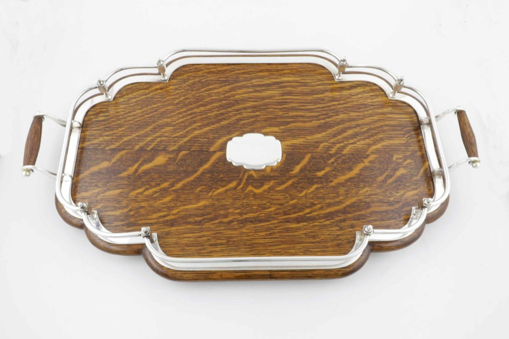 A late Victorian shaped English oak serving tray featuring a silver-plated raised gallery rail, twin wood-mounted handles, and a central blank silver cartouche. View XIII