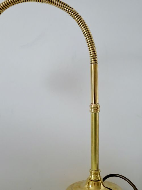 fig 1. An antique polished brass task lamp featuring a heavy stepped circular base, a flexible gooseneck arm, and a brass bulb socket.