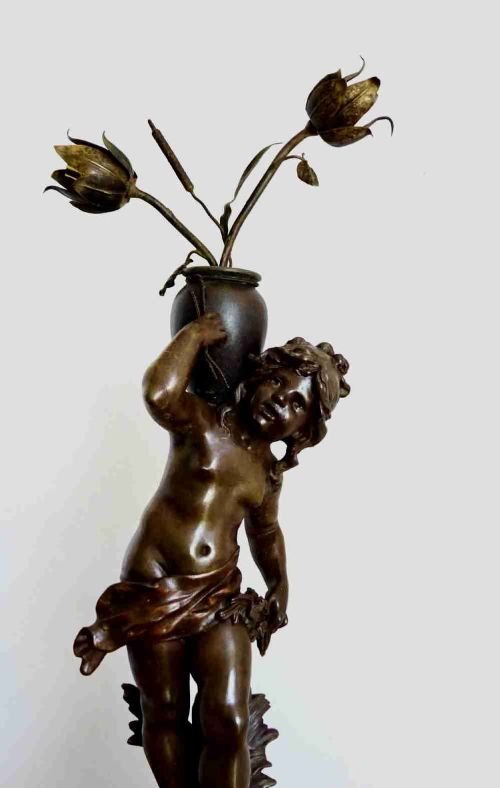 fig 1. A bronzed spelter table lamp featuring a sculpted cherub figure holding a urn, with floral stem lights mounted on a round marble base.