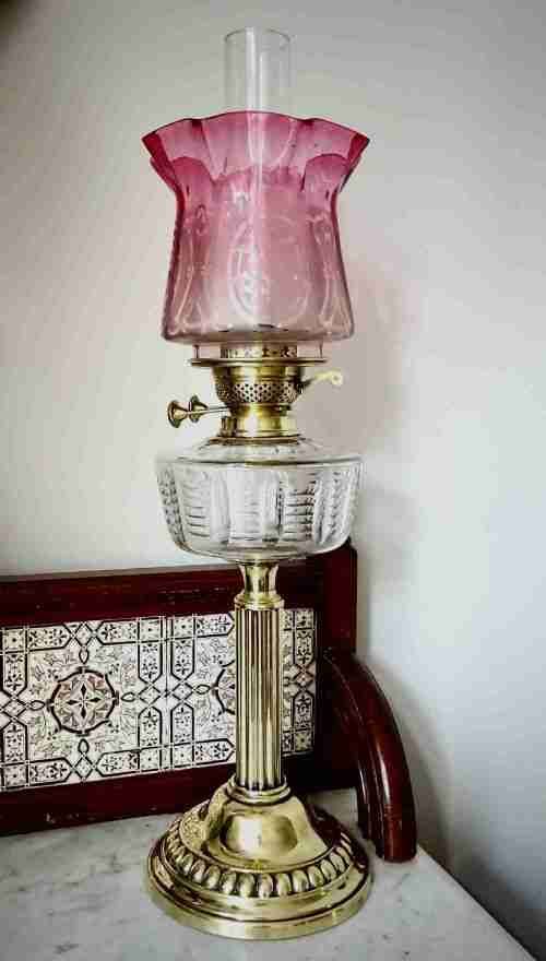 C1900 AN OIL LAMP WITH CRANBERRY GLASS SHADE