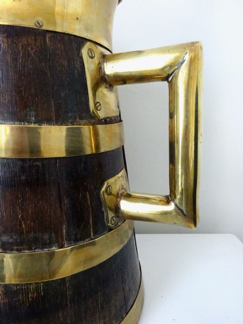 fig 2. A Victorian coopered oak jug constructed from dark wooden staves with polished brass binding bands, rim, and handle.