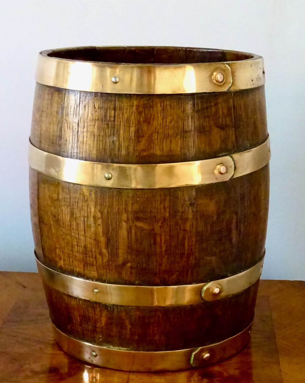 AN OAK COOPERED BARREL WITH BRONZE BANDING