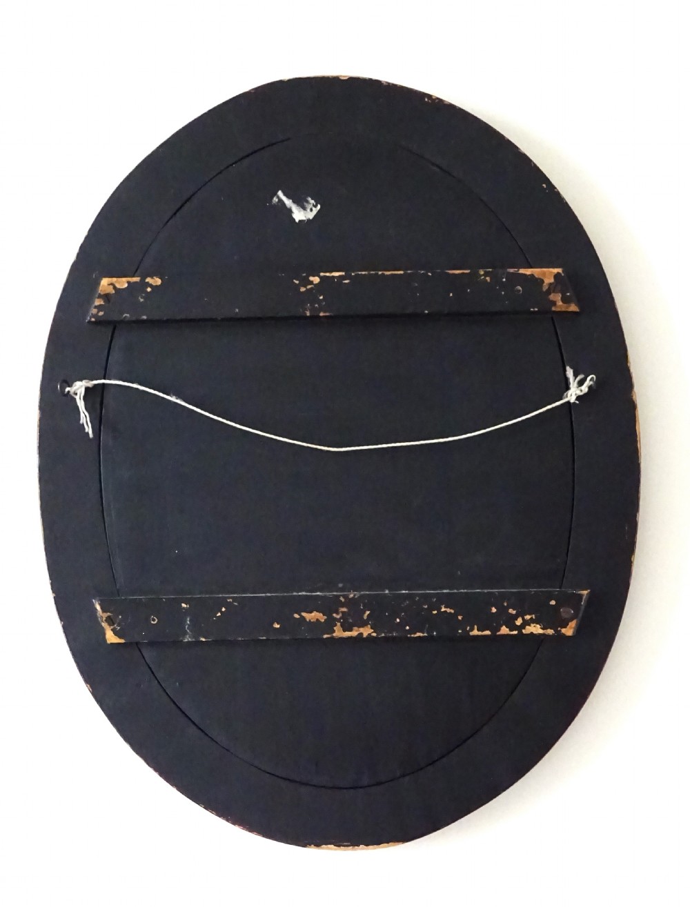 An oval red-lacquered framed artwork depicting a Japanese scene with Mount Fuji and a rickshaw in mother-of-pearl and abalone shell inlay against a black background. View V