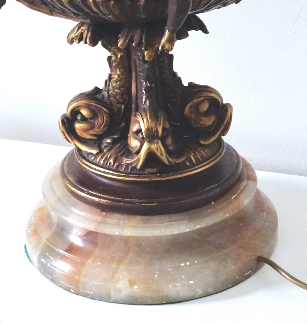 A cast metal Neoclassical table lamp base featuring sculpted cherubs and dolphin motifs mounted on a round onyx plinth. View III