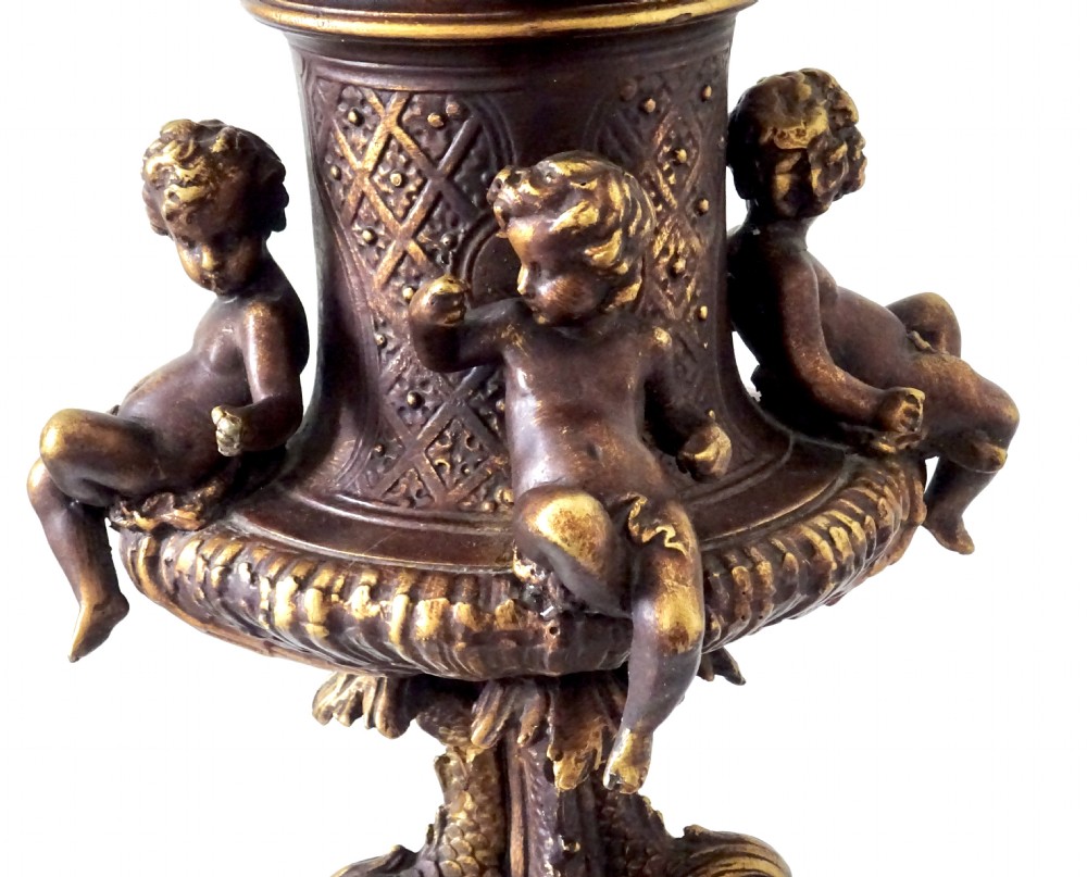 A cast metal Neoclassical table lamp base featuring sculpted cherubs and dolphin motifs mounted on a round onyx plinth. View VI
