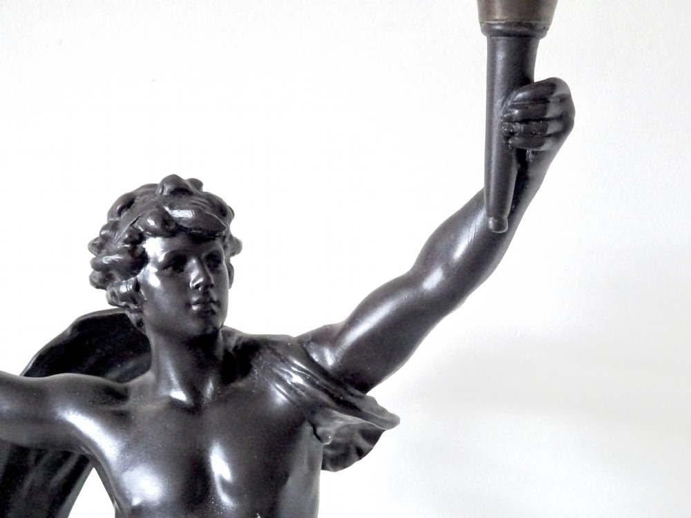 A dark bronze-patinated spelter figure of a classical youth holding a torch light socket on a stepped plinth base. View VII