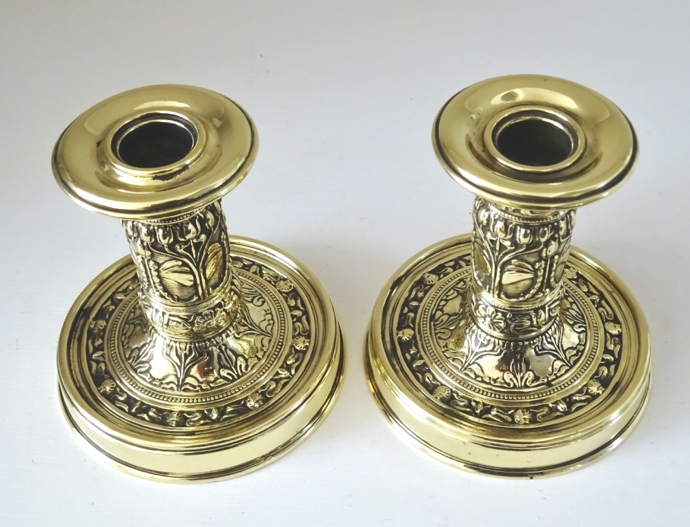 A PAIR OF SMALL DECORATIVE BRASS CANDLESTICKS