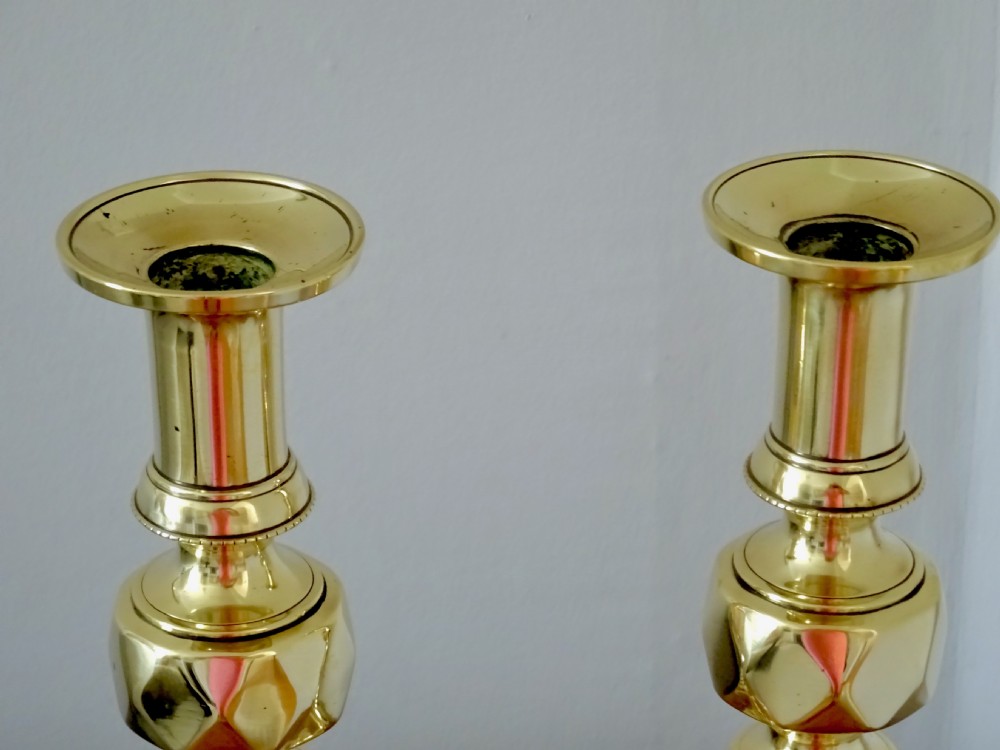 A pair of tall turned brass candlesticks featuring beehive stems, diamond knops, and square bases with canted corners. View III