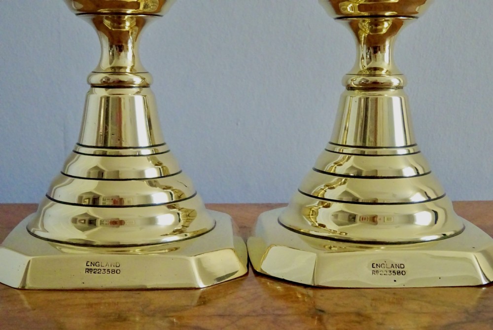 A pair of tall turned brass candlesticks featuring beehive stems, diamond knops, and square bases with canted corners. View IV