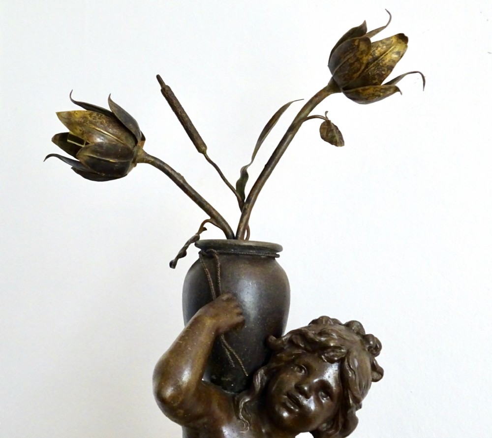 A bronzed spelter table lamp featuring a sculpted cherub figure holding a urn, with floral stem lights mounted on a round marble base. View III