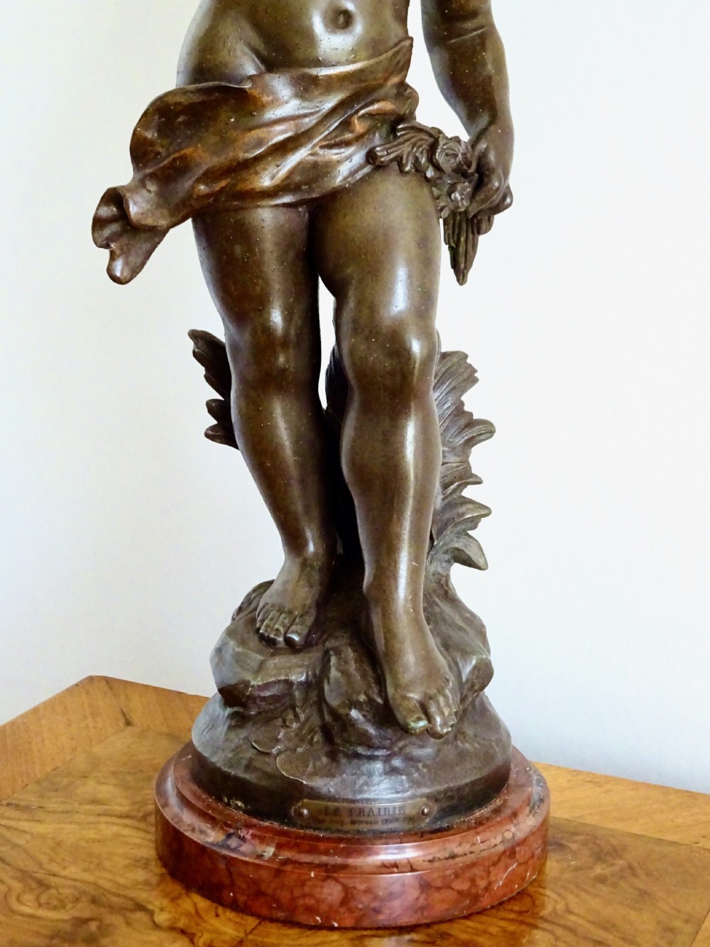 A bronzed spelter table lamp featuring a sculpted cherub figure holding a urn, with floral stem lights mounted on a round marble base. View VII