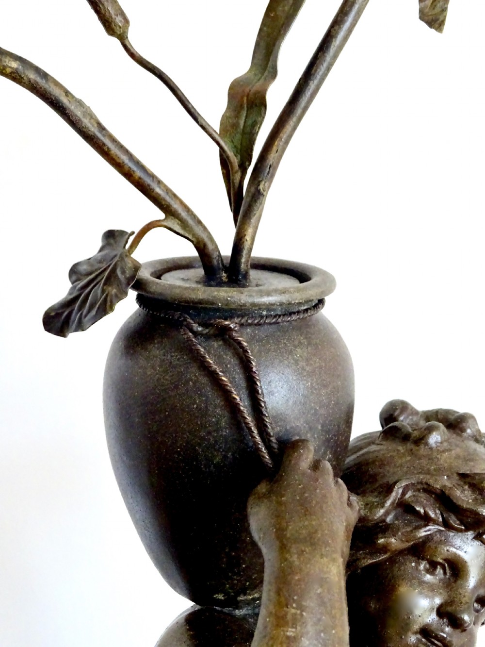 A bronzed spelter table lamp featuring a sculpted cherub figure holding a urn, with floral stem lights mounted on a round marble base. View IV