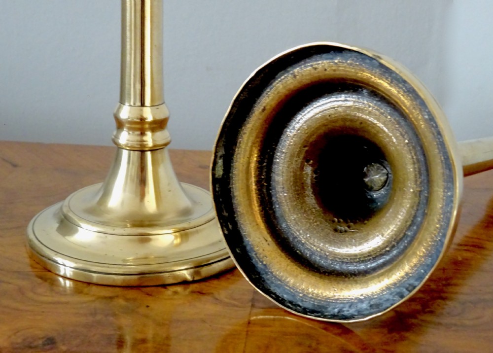 A pair of tall Victorian polished brass candlesticks featuring turned shafts and circular stepped bases. View II