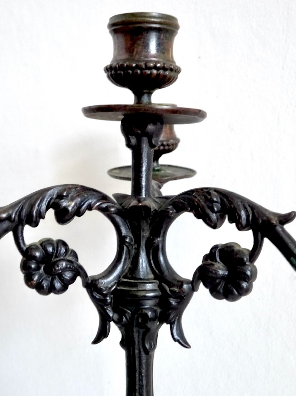 A pair of Victorian dark bronze three-light candelabra featuring scrollwork arms, cast detail, and tripod bases. View IV