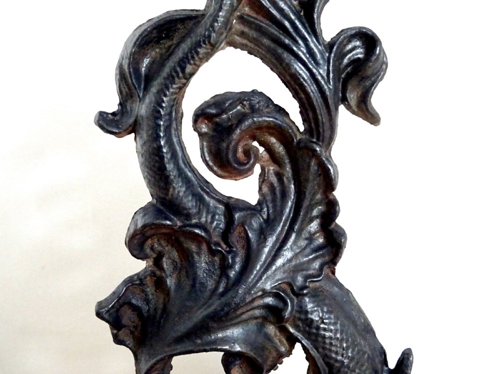 A heavy black cast iron doorstop featuring a mythological dolphin intertwined with acanthus scrollwork set upon a rectangular molded base. View III