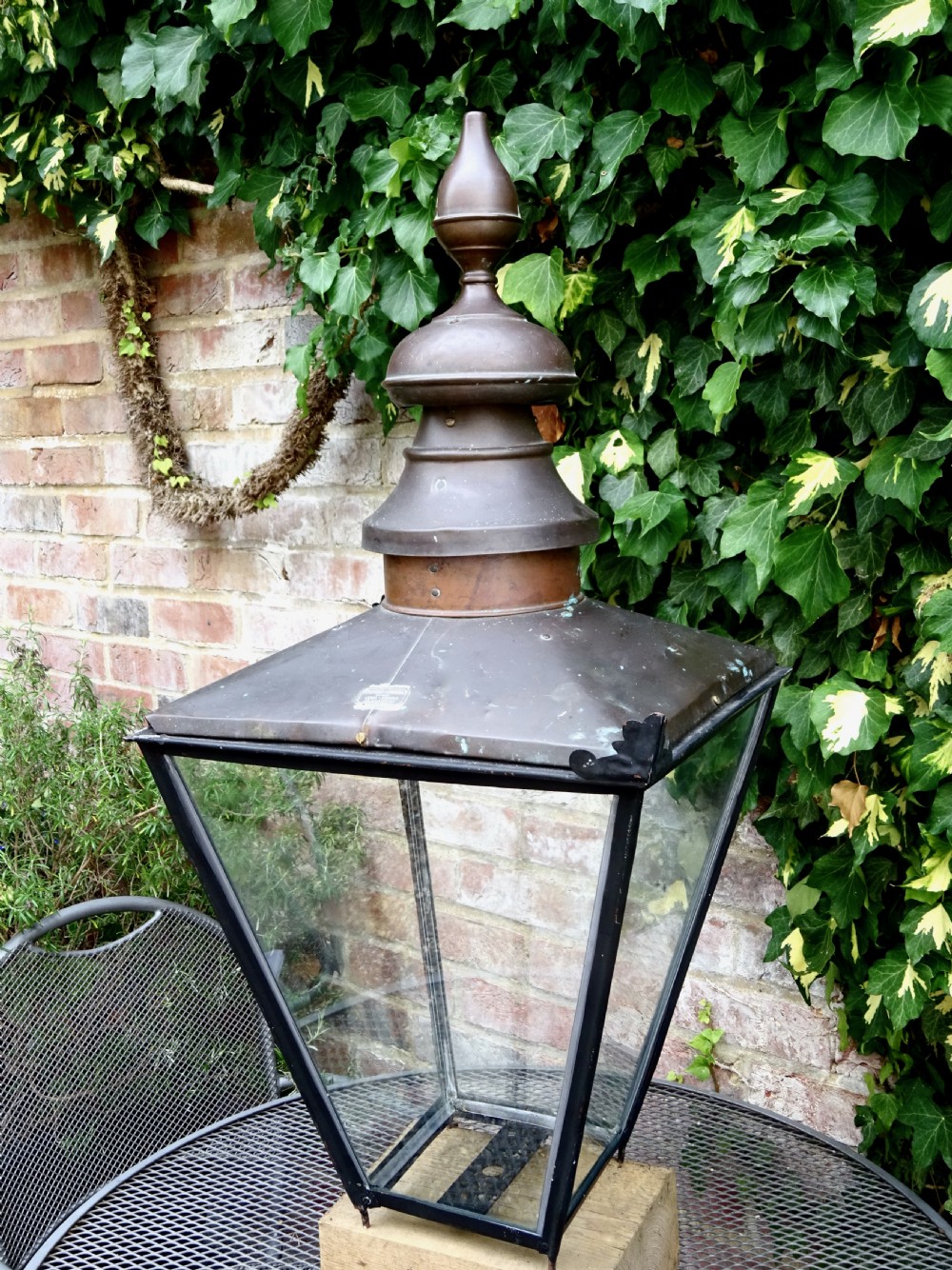A late Victorian copper street lantern featuring a tiered cap with a finial, clear glass panels tapering downwards, and a black patinated frame. View VIII