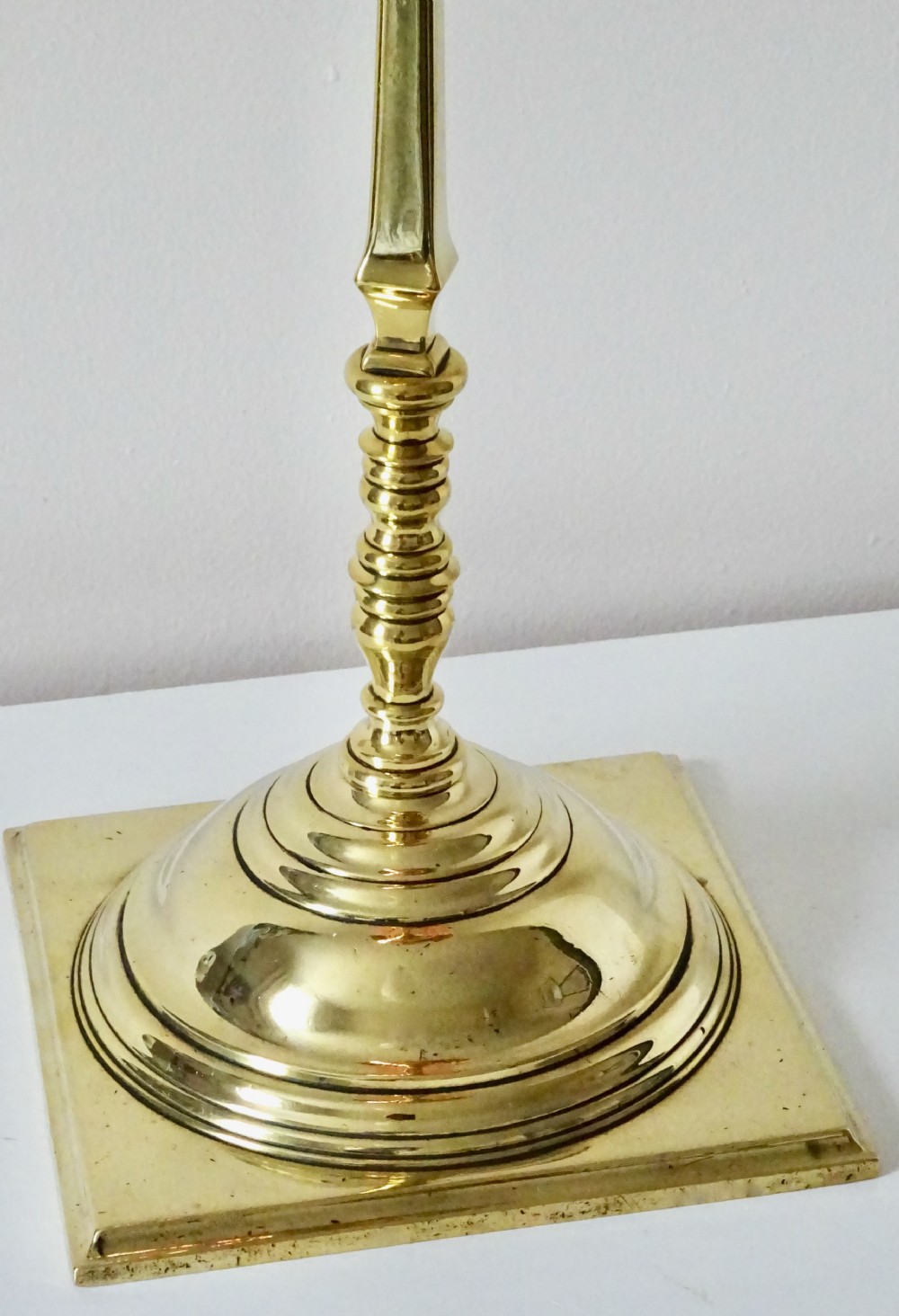 An Arts and Crafts oil lamp featuring a square brass base, a slender turned column stem, a polished copper reservoir, and a pale yellow frilled vaseline glass shade. View IV