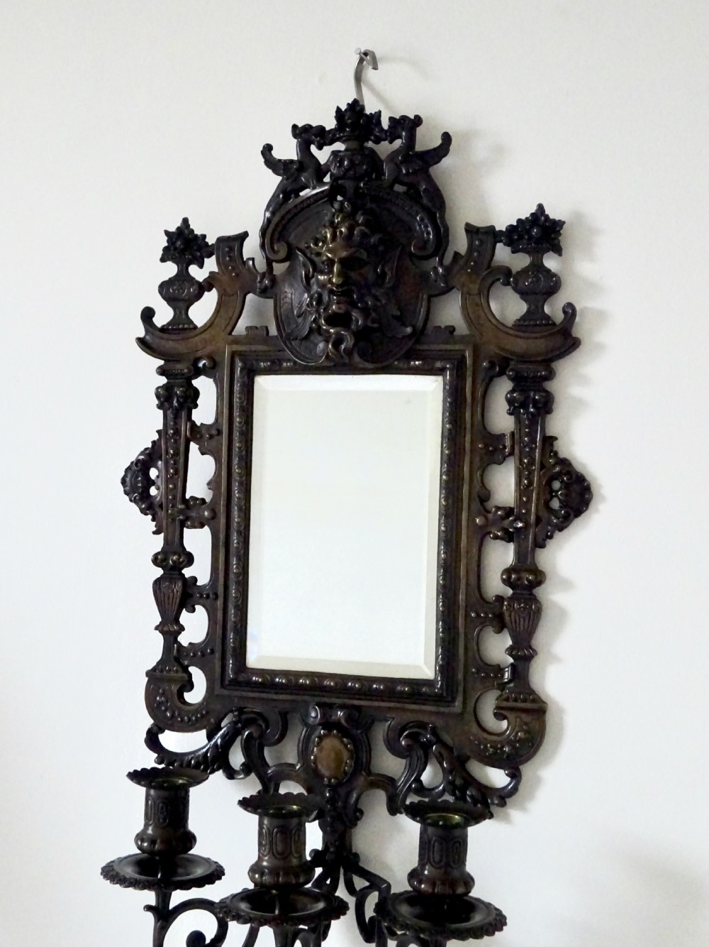 A pair of cast bronze girandole wall sconces featuring rectangular mirrors, three candle branches, and decorative scrollwork frames topped with carved mascaron masks. View VI