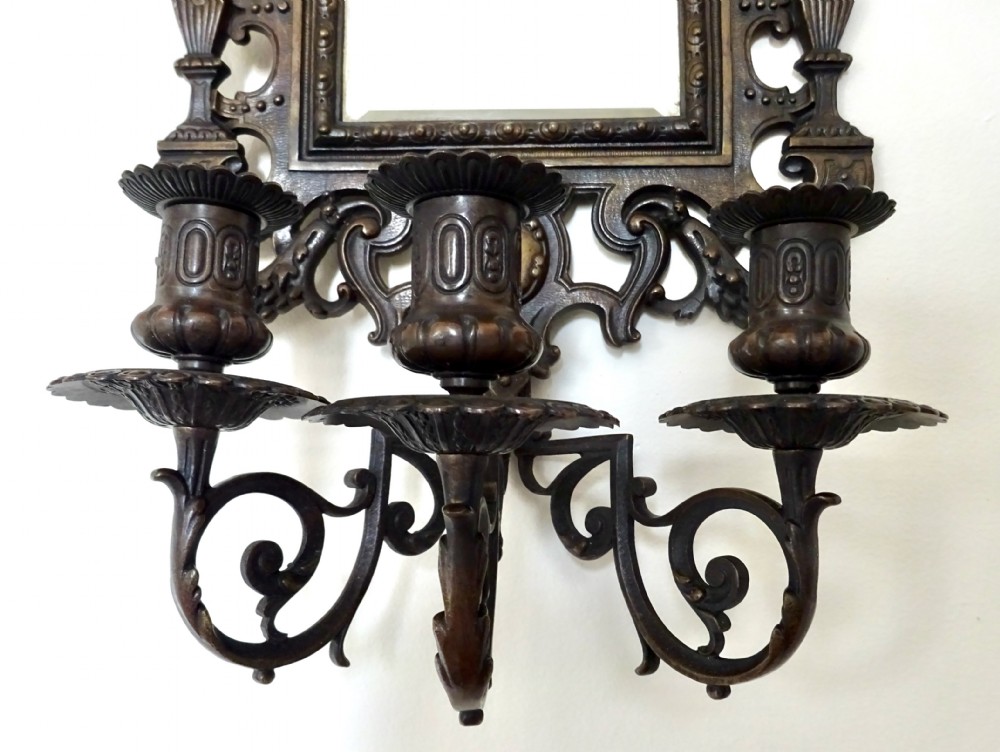 A pair of cast bronze girandole wall sconces featuring rectangular mirrors, three candle branches, and decorative scrollwork frames topped with carved mascaron masks. View III