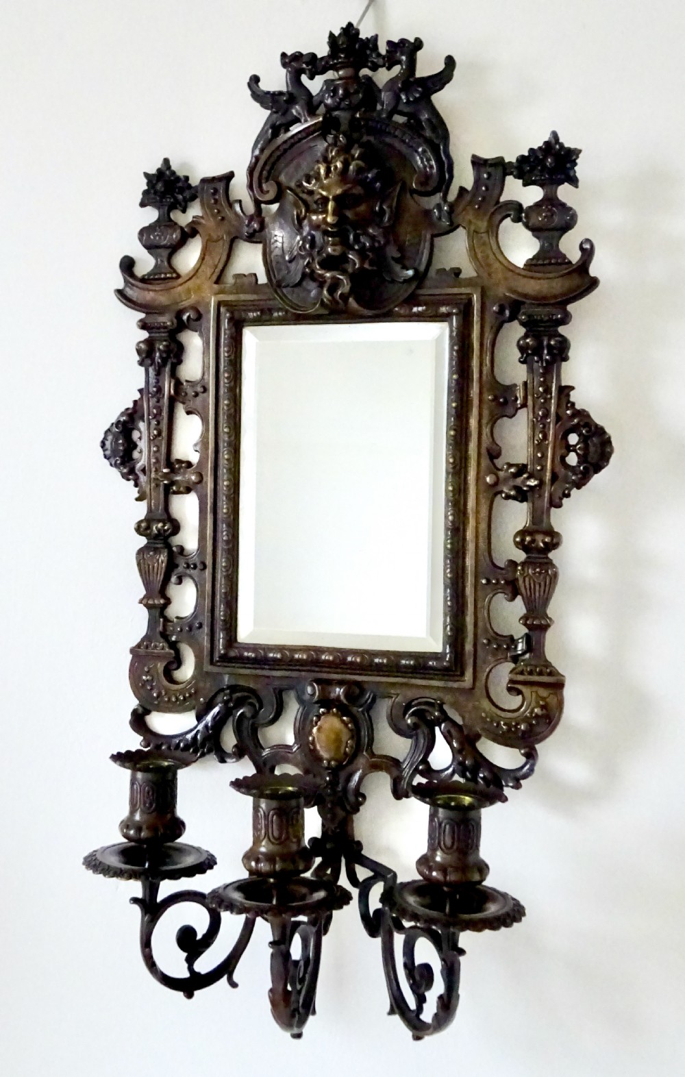 A pair of cast bronze girandole wall sconces featuring rectangular mirrors, three candle branches, and decorative scrollwork frames topped with carved mascaron masks. View IV