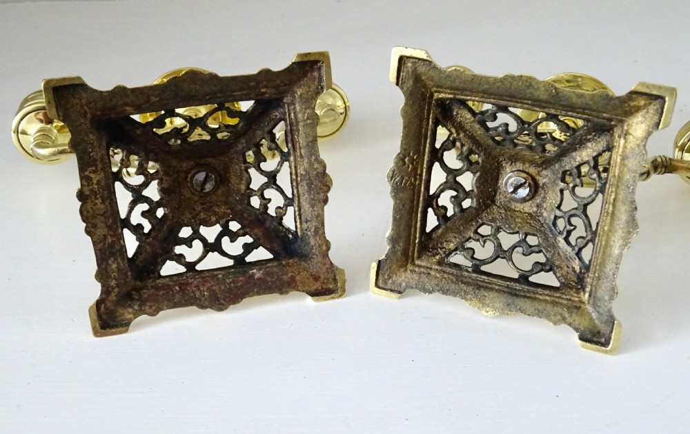 A pair of cast brass three-light candelabras featuring central grotesque mask motifs and pierced square bases. View V