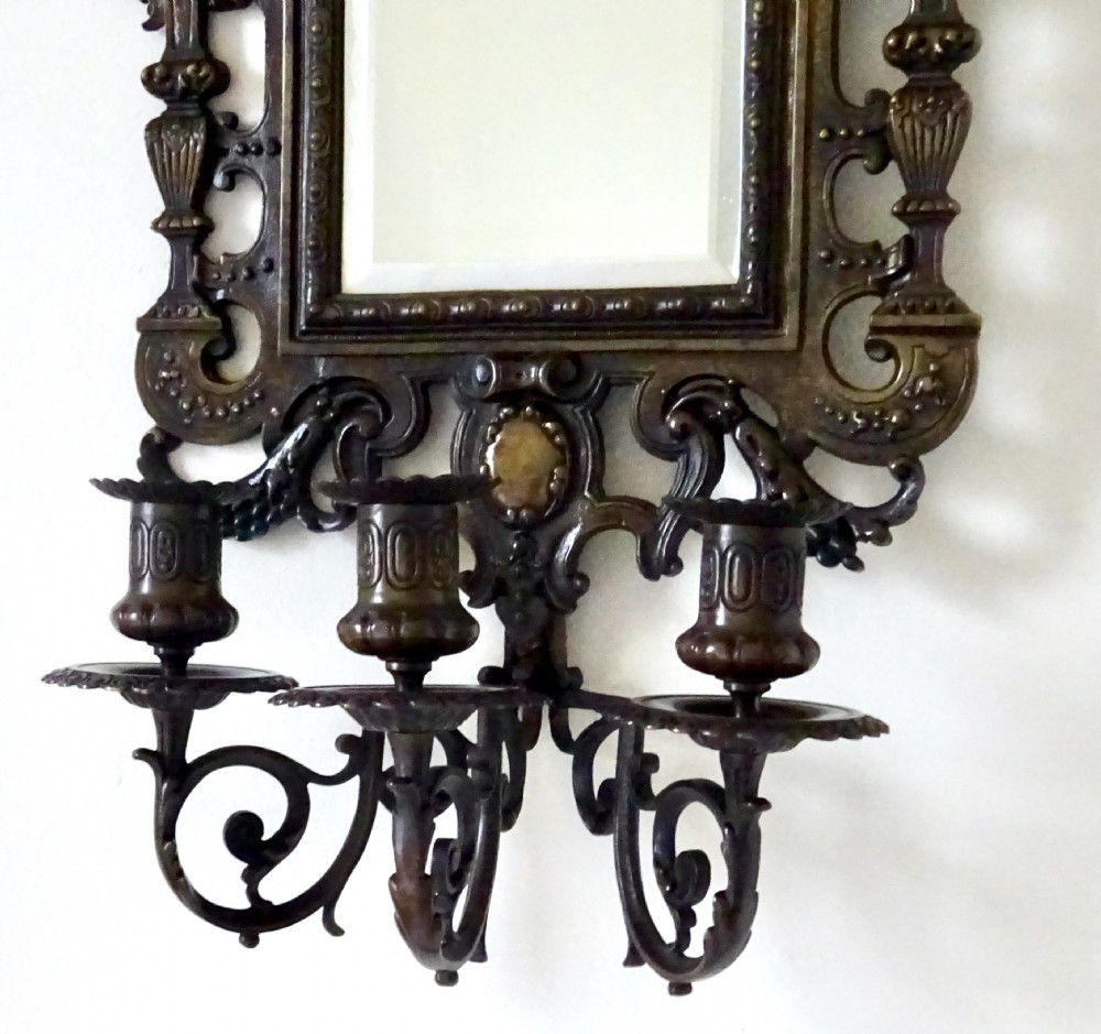 A pair of cast bronze girandole wall sconces featuring rectangular mirrors, three candle branches, and decorative scrollwork frames topped with carved mascaron masks. View VIII