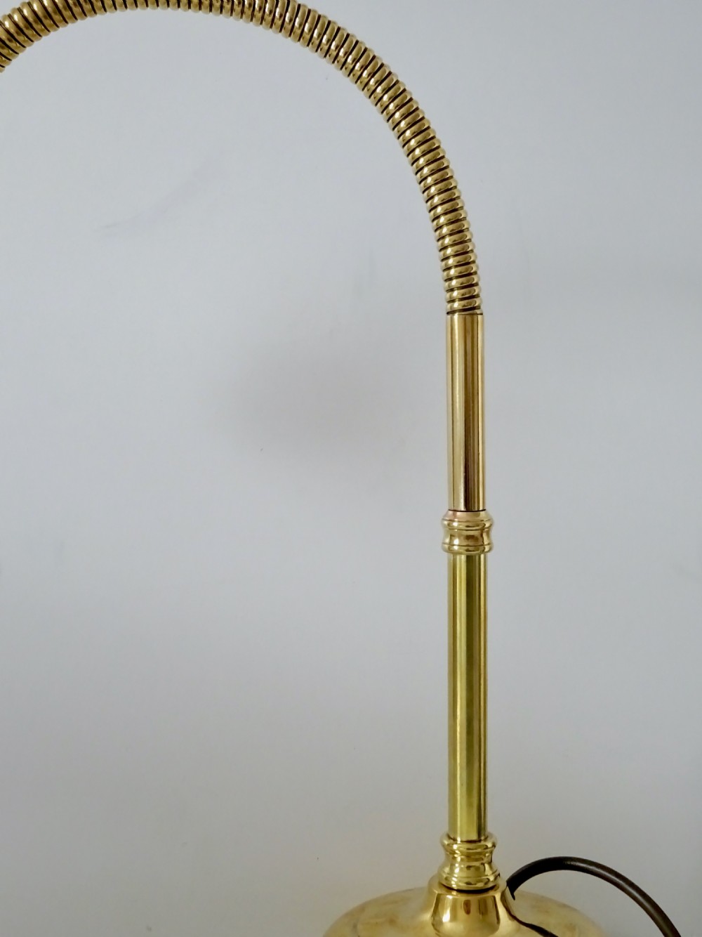 An antique polished brass task lamp featuring a heavy stepped circular base, a flexible gooseneck arm, and a brass bulb socket. View II