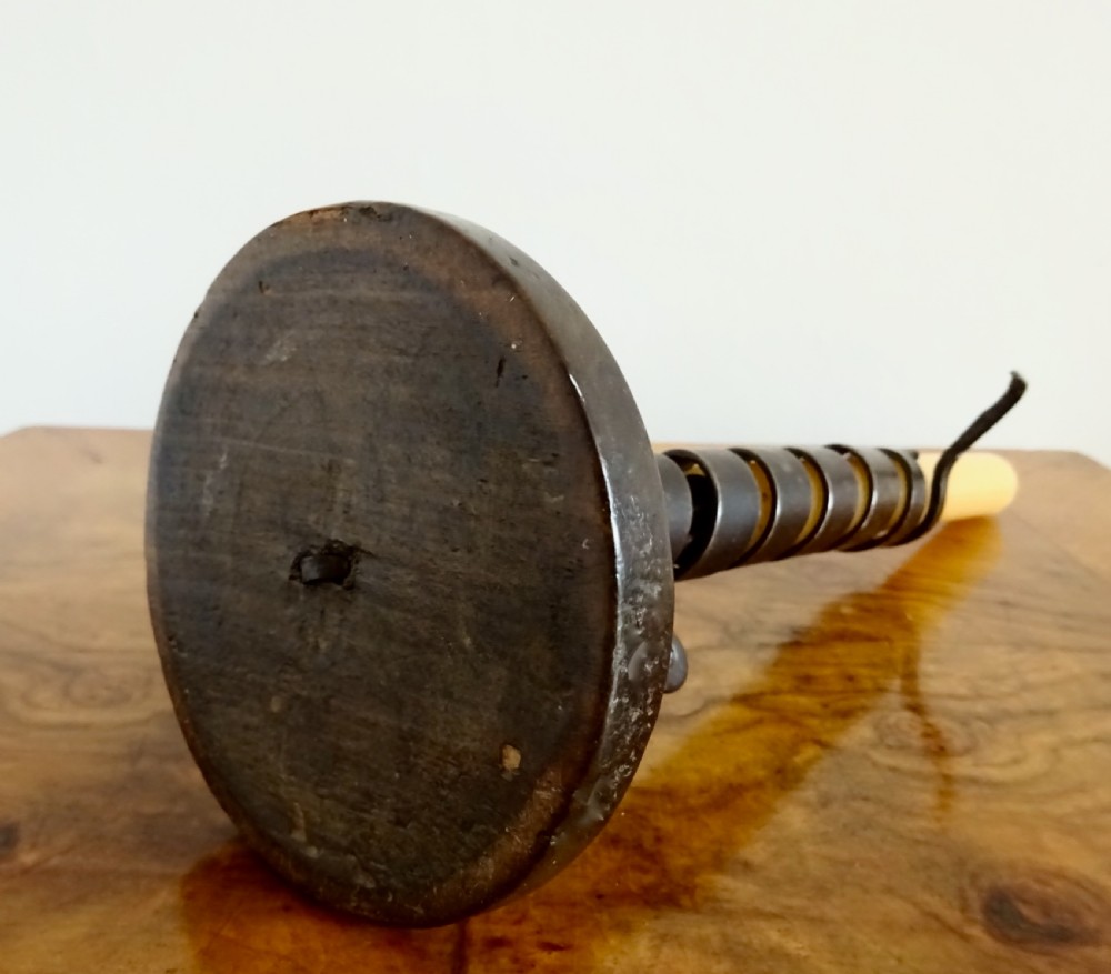 A wrought iron spiral candlestick with an adjustable side hook set into a circular turned wooden base. View IV