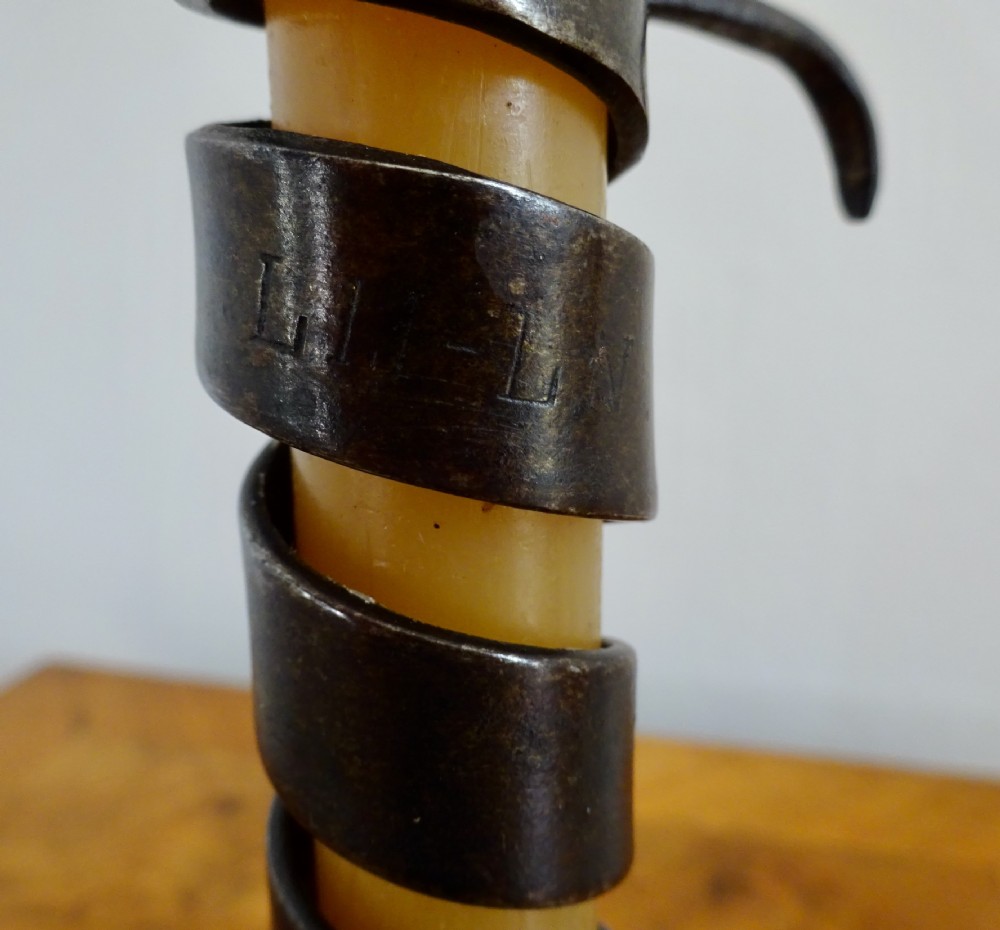 A wrought iron spiral candlestick with an adjustable side hook set into a circular turned wooden base. View VI
