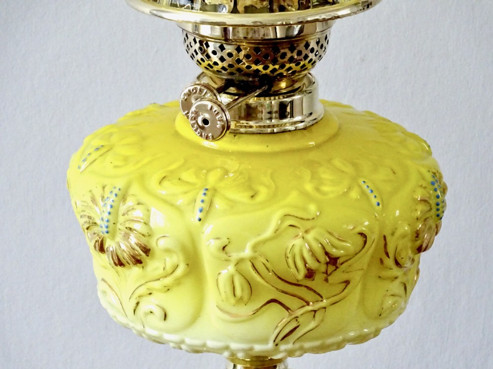 A late Victorian oil lamp featuring a yellow glass frilled shade, a moulded yellow glass reservoir, a turned brass pedestal base, and a tall clear glass chimney. View VI