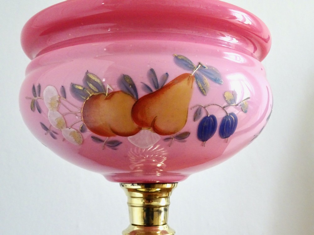 An early twentieth-century brass oil lamp featuring a pink hand-painted glass reservoir, an etched floral glass globe shade, a clear glass chimney, and a black stepped base. View III
