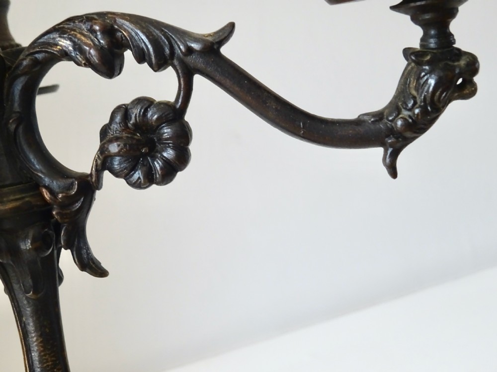A pair of Victorian dark bronze three-light candelabra featuring scrollwork arms, cast detail, and tripod bases. View VII