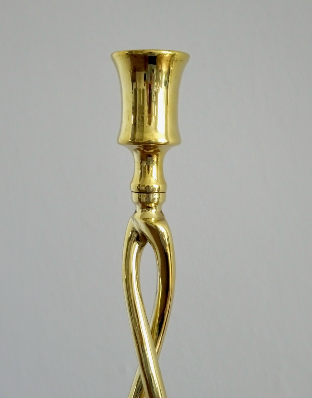 A pair of polished gold brass candlesticks featuring open-twist stems resting on circular bases. View III