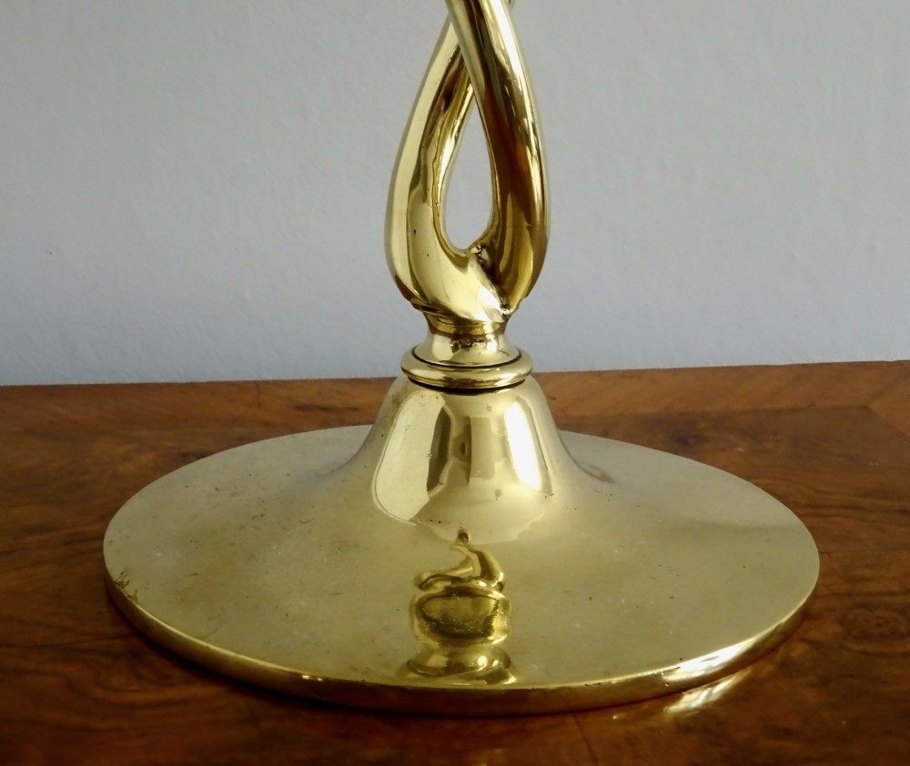 A pair of polished gold brass candlesticks featuring open-twist stems resting on circular bases. View VII