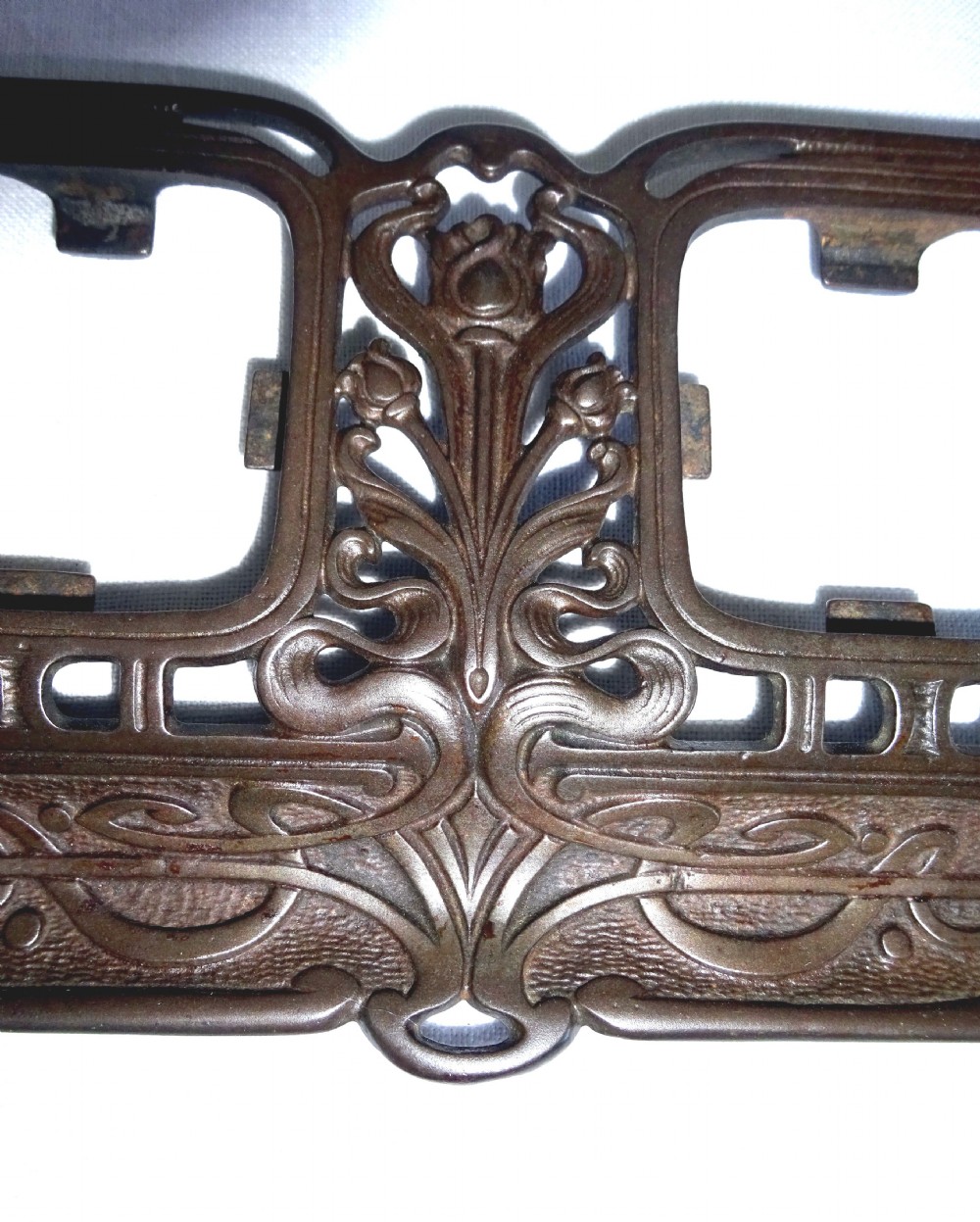 An Art Nouveau dark metal double inkstand featuring pierced floral scrollwork and two square glass inkwells with embossed metal lids. View III