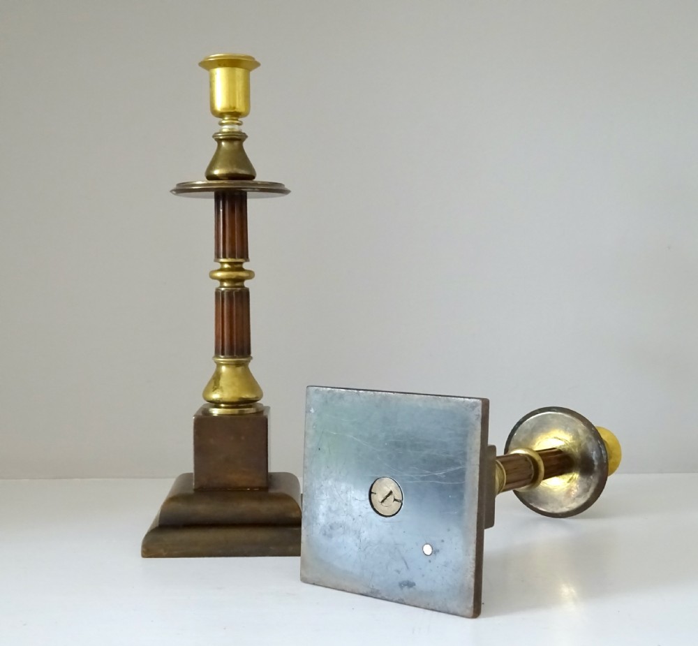 A pair of Edwardian bronze and brass candlesticks featuring fluted shafts, turned sconces, and stepped square bases. View V
