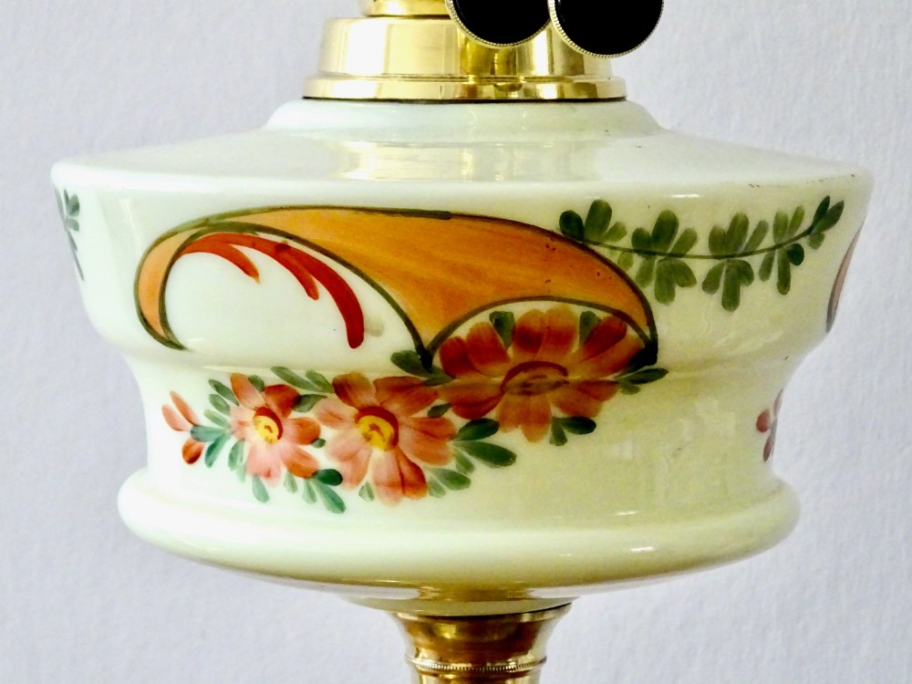 An antique brass oil lamp featuring a hand-painted floral glass font, a frosted etched globe shade, and a tall clear glass chimney on a stepped circular base. View II