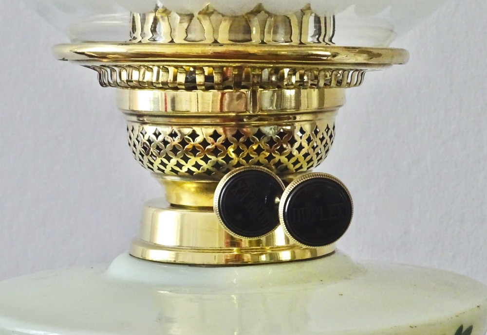 An antique brass oil lamp featuring a hand-painted floral glass font, a frosted etched globe shade, and a tall clear glass chimney on a stepped circular base. View III