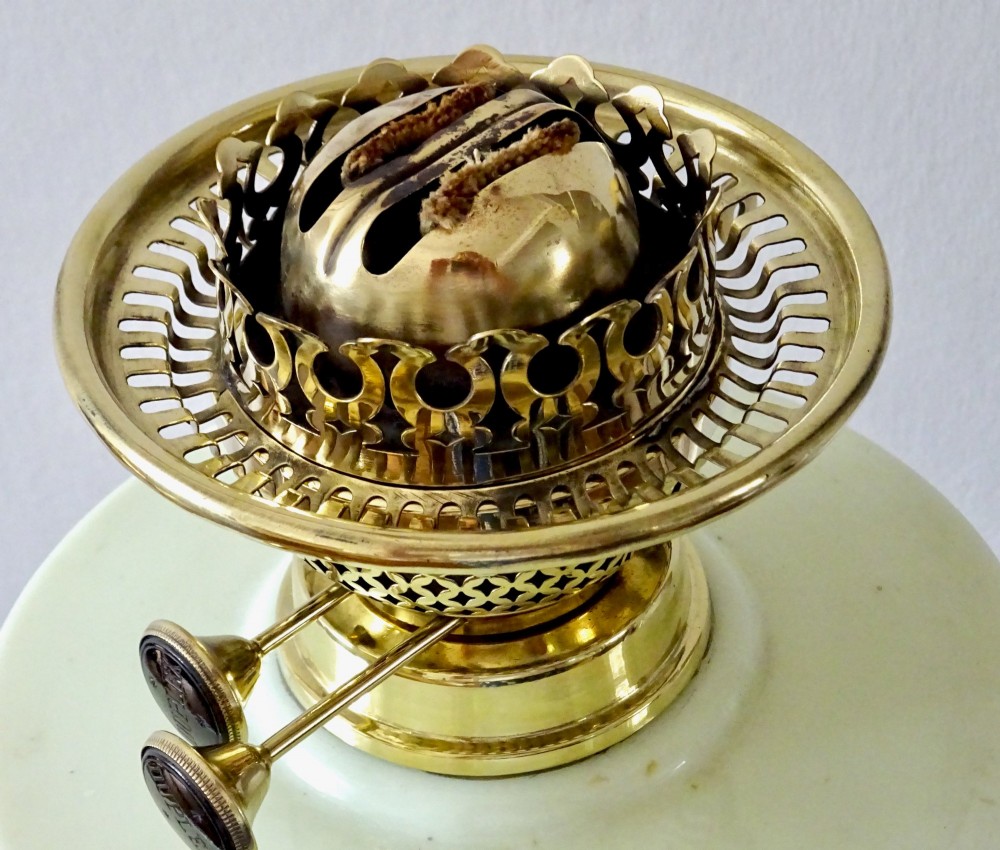 An antique brass oil lamp featuring a hand-painted floral glass font, a frosted etched globe shade, and a tall clear glass chimney on a stepped circular base. View IV