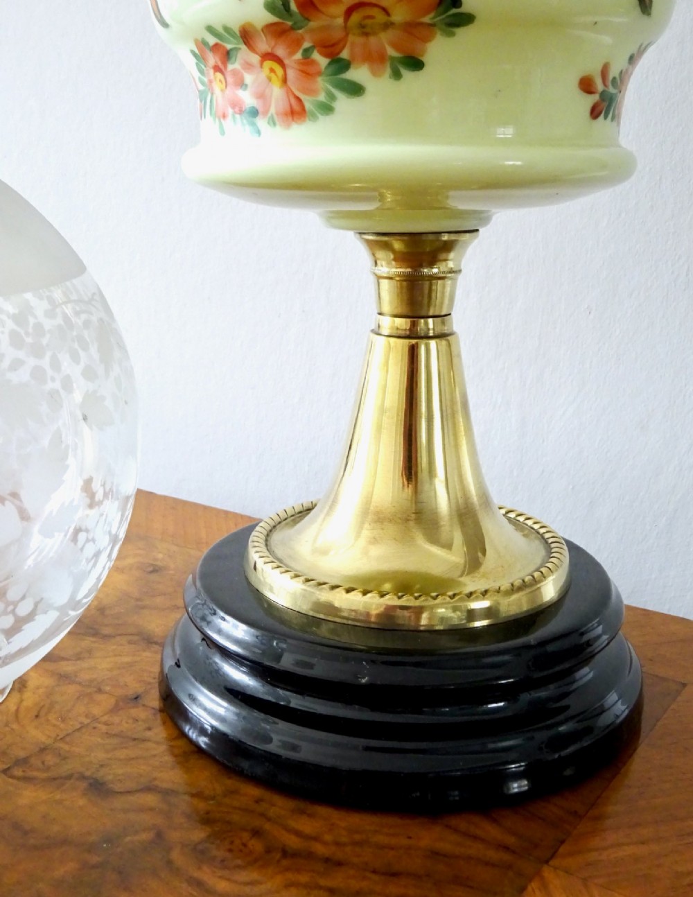 An antique brass oil lamp featuring a hand-painted floral glass font, a frosted etched globe shade, and a tall clear glass chimney on a stepped circular base. View VII