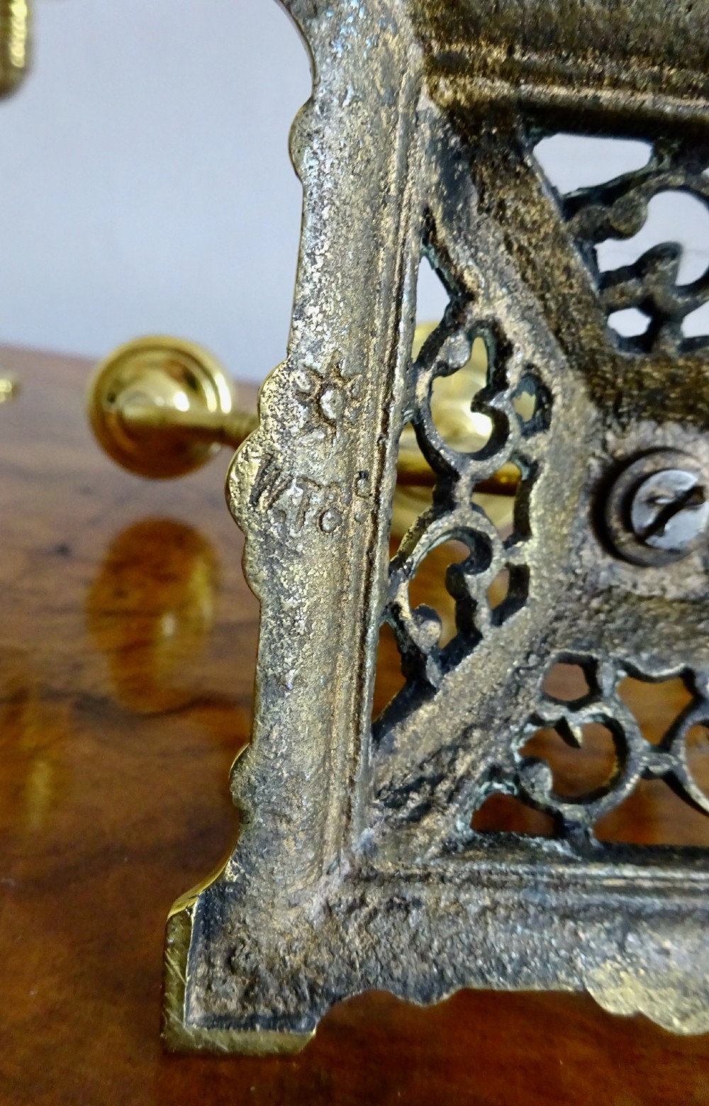 A pair of cast brass three-light candelabras featuring central grotesque mask motifs and pierced square bases. View IX