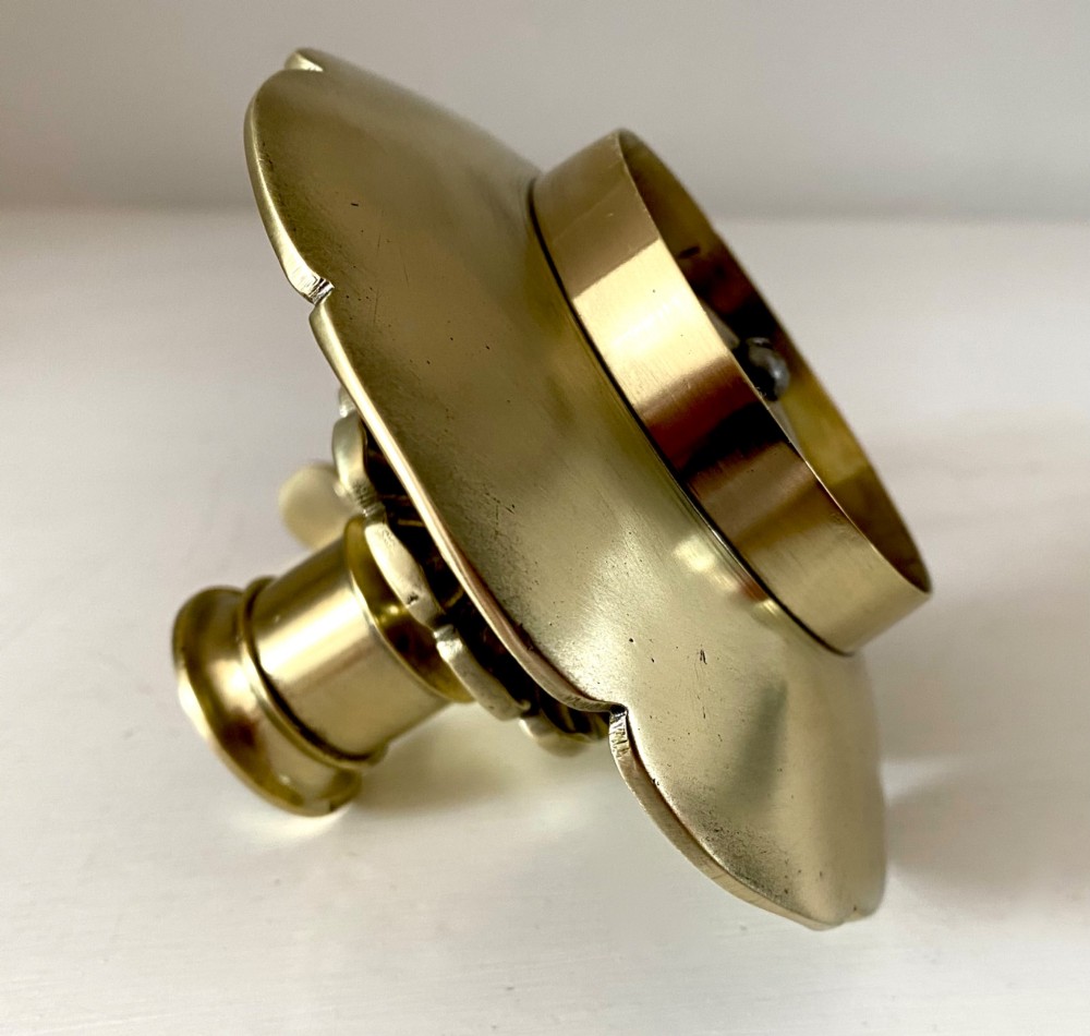 An antique French brass chamberstick featuring a scalloped tray base, turned candle socket, and a cast handle shaped like a grotesque face. View VI